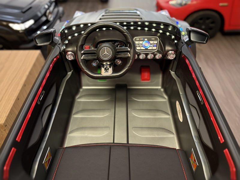 Interior view of the Mercedes AMG GT Drift Edition 24V Ride on car showing the steering wheel. dash, leg room, and gas and brake pedals