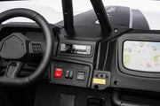 Close-up of a black electric ride-on toy vehicle dashboard, featuring a steering wheel, control buttons, a small screen showing a map, and a roll bar.