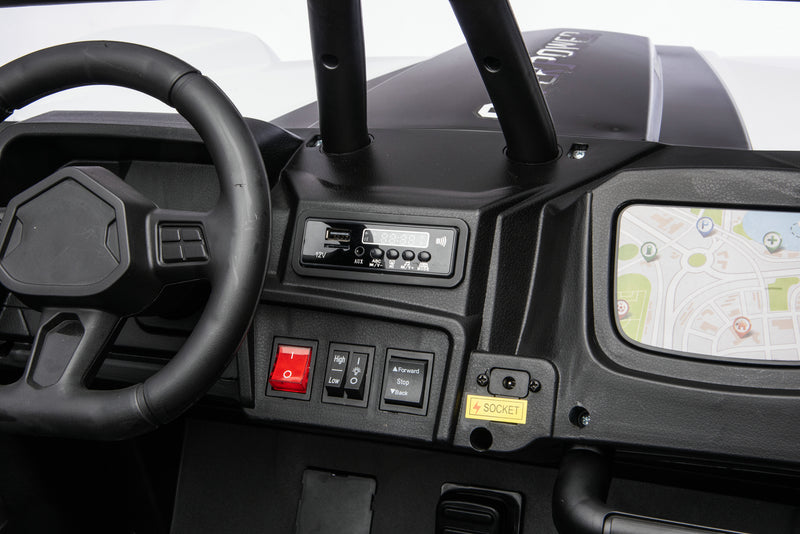 Close-up of a black electric ride-on toy vehicle dashboard, featuring a steering wheel, control buttons, a small screen showing a map, and a roll bar.