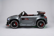 Side view of the licensed Mercedes-Benz AMG GT 24V electric ride-on car in matte grey, equipped with a wide-body kit and deep dish sport-style rims