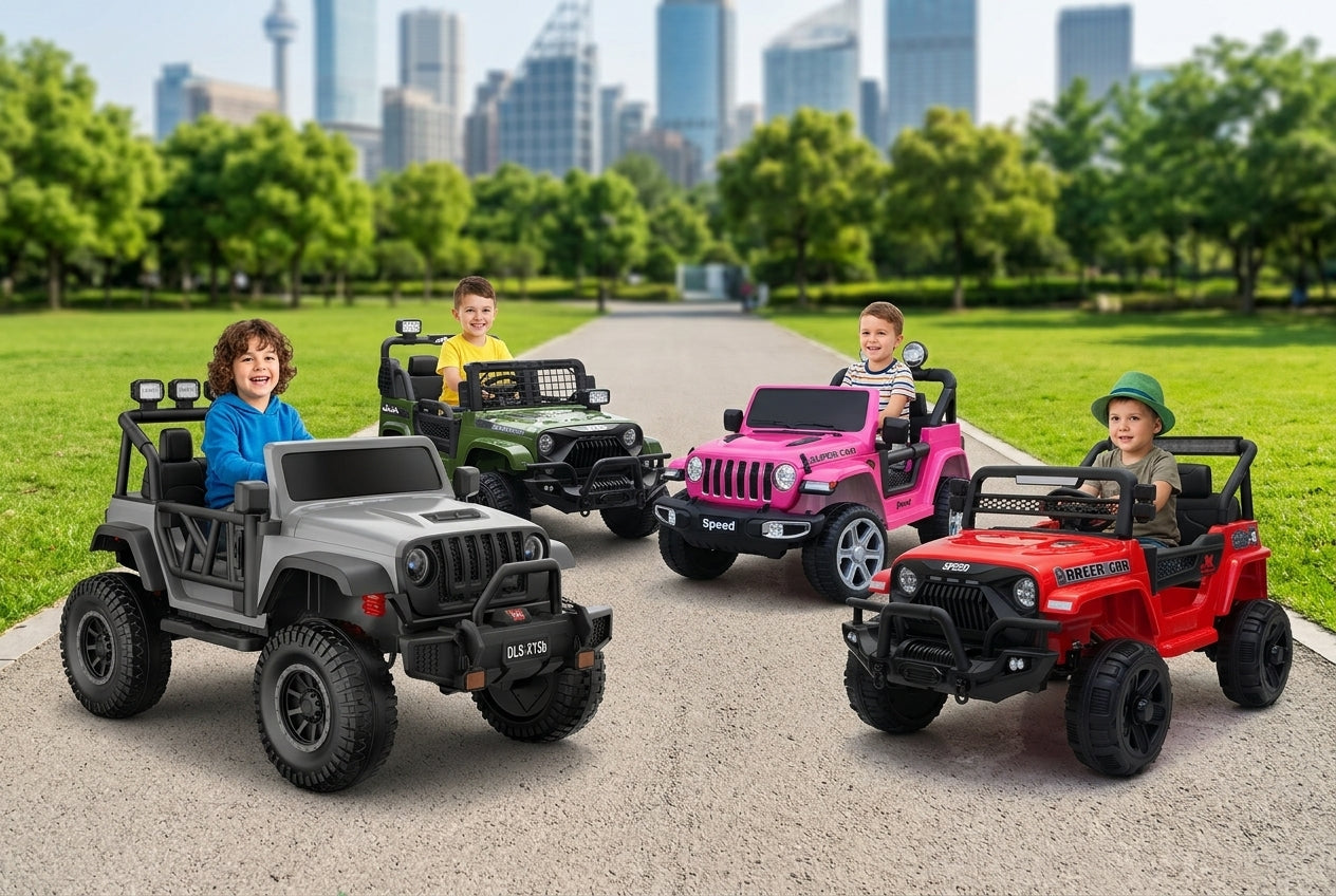 Four children driving ride-on toy Jeeps on a paved path in a park, with green grass, trees, and a city skyline in the background. The toy vehicles are gray, green, pink, and red.