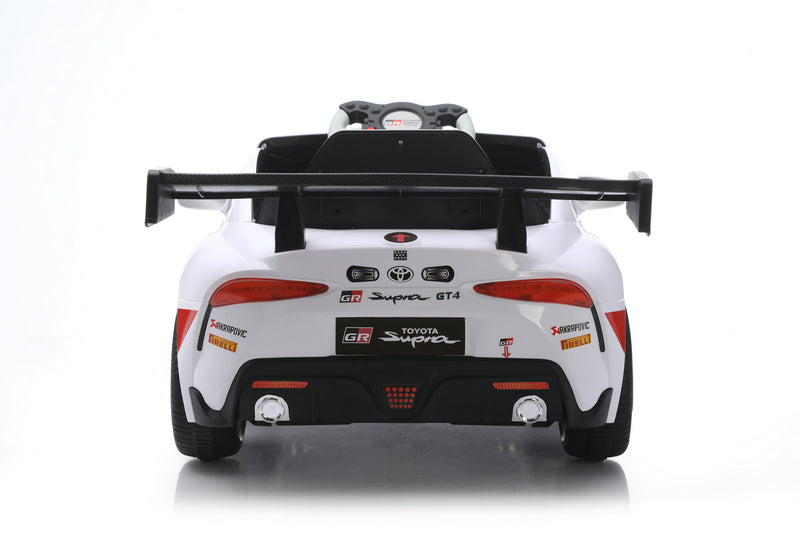 A white Toyota Supra GT-R licensed ride-on toy car, photographed from the rear on a clean white studio background with a subtle reflection.