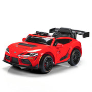 A red Toyota Supra-style children's ride-on toy car with black wheels, a black interior, and a large rear spoiler, photographed on a clean white studio background.