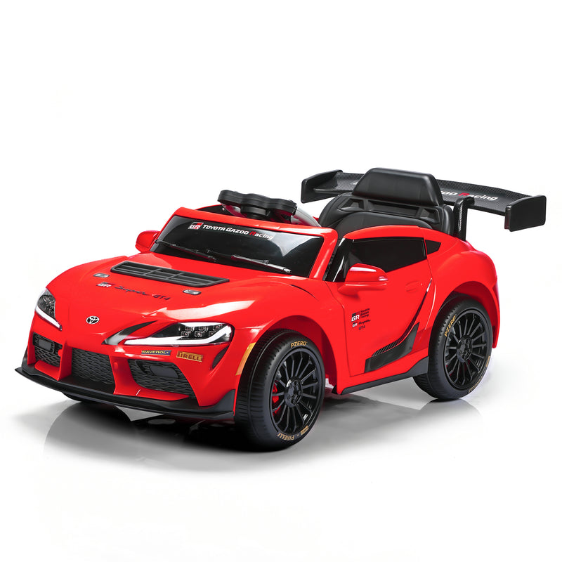 A red Toyota Supra-style children's ride-on toy car with black wheels, a black interior, and a large rear spoiler, photographed on a clean white studio background.