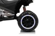 Close-up of a black kids' ride-on ATV or quad bike wheel and side body panel on a white studio background. The tire is black with a bright white ring around the wheel, and part of the side panel shows the word 'AD' and '4X4'.