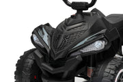 Close-up of a black children's ride-on ATV with rugged tires, a textured front grille, and clear headlights on a white background.